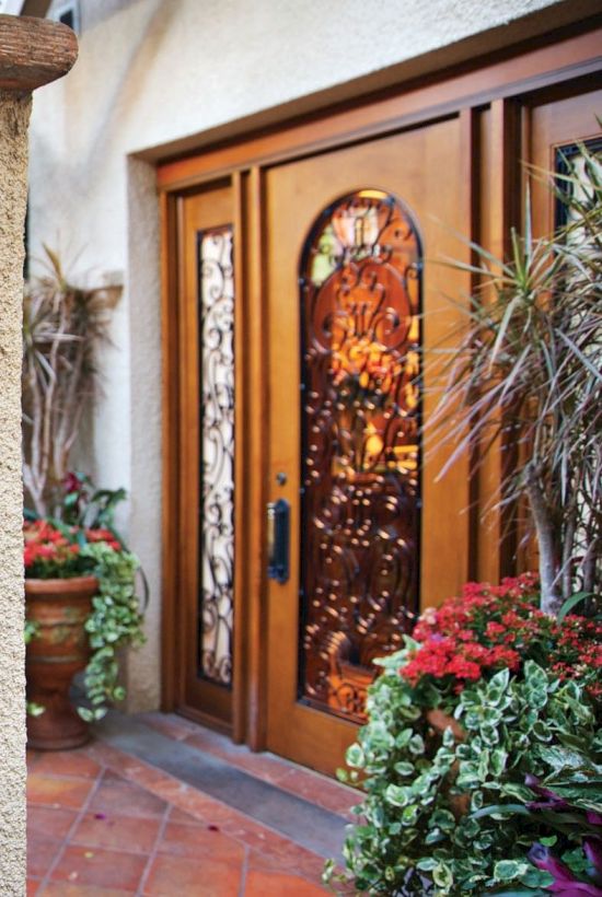A sign reads &ldquo;Kelly&rsquo;s Spa&rdquo; with a woman&rsquo;s profile crest; a decorative wooden door and potted plants welcome guests at the entrance.